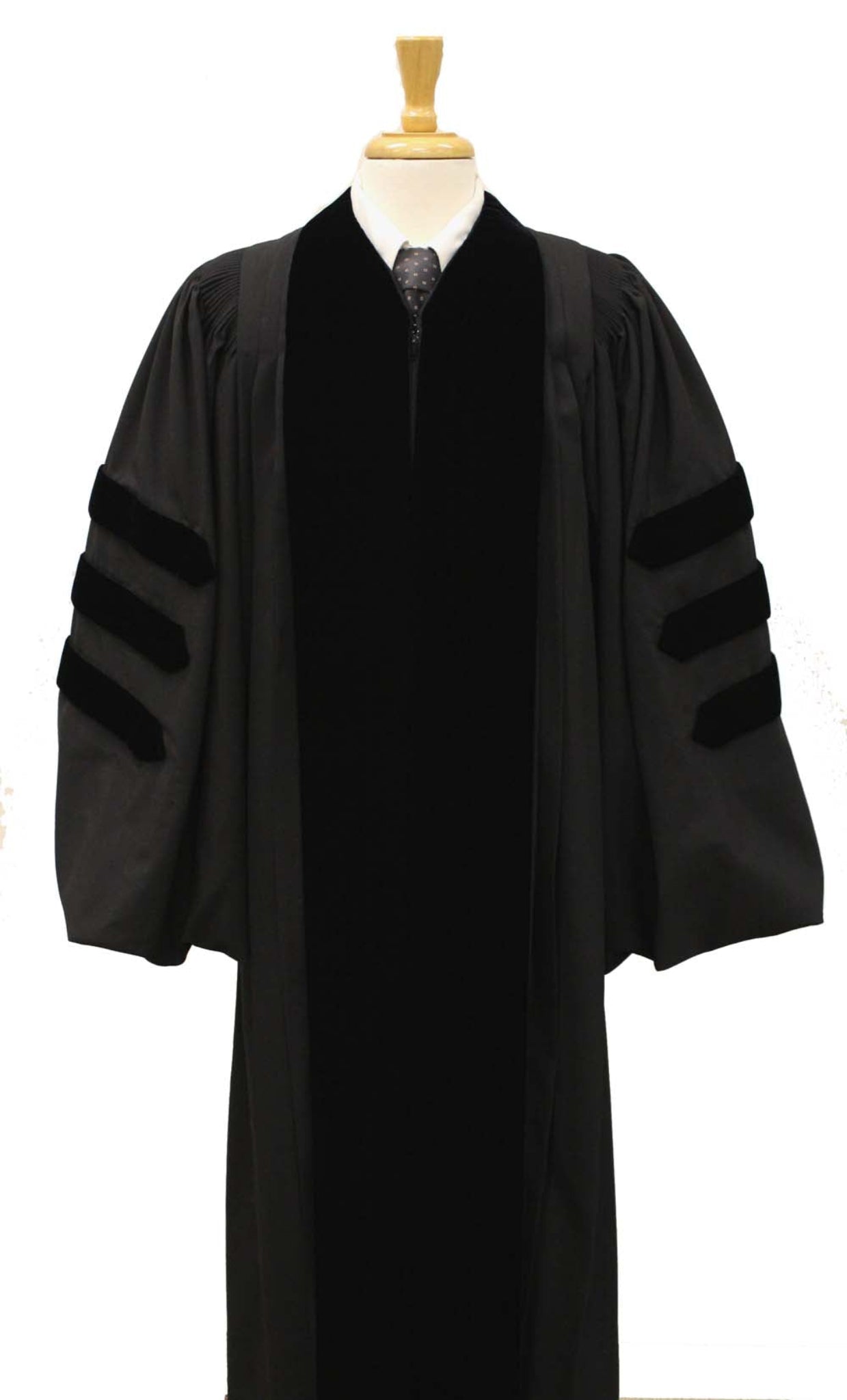 Black doctoral academic gown with velvet panels and three velvet bars on each sleeve, displayed on a mannequin torso with a wooden stand.