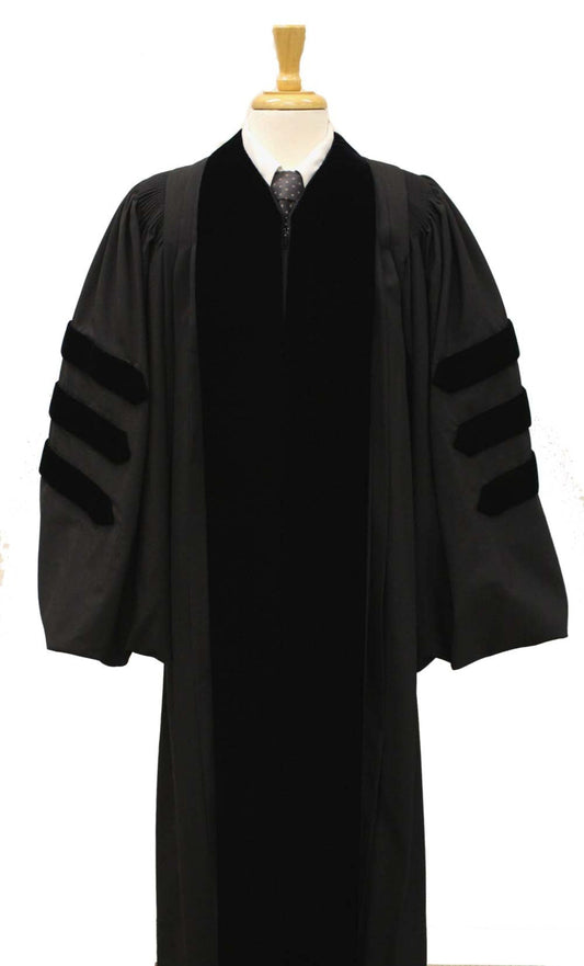 Black doctoral academic gown with velvet panels and three velvet bars on each sleeve, displayed on a mannequin torso with a wooden stand.
