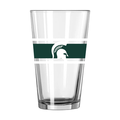Pint glass cup with two white stripes and a thicker green stripe in the middle. On top of the green stripe is a Spartan Helmet logo in white. 